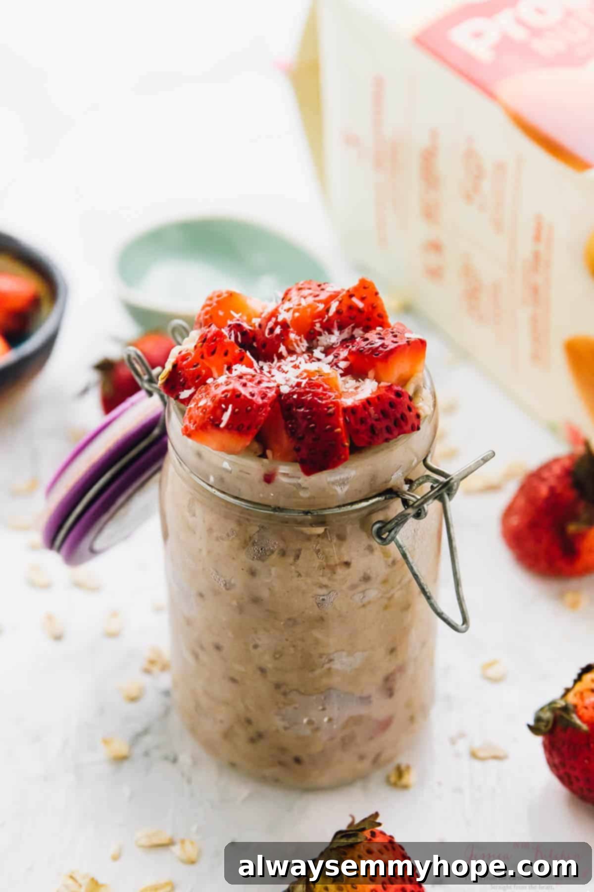 These sweet coconut overnight oats are the easiest breakfast ever! Just 5 minutes of prep for a tasty grab-and-go breakfast. Jar of strawberry coconut overnight oats topped with fresh berries and coconut.