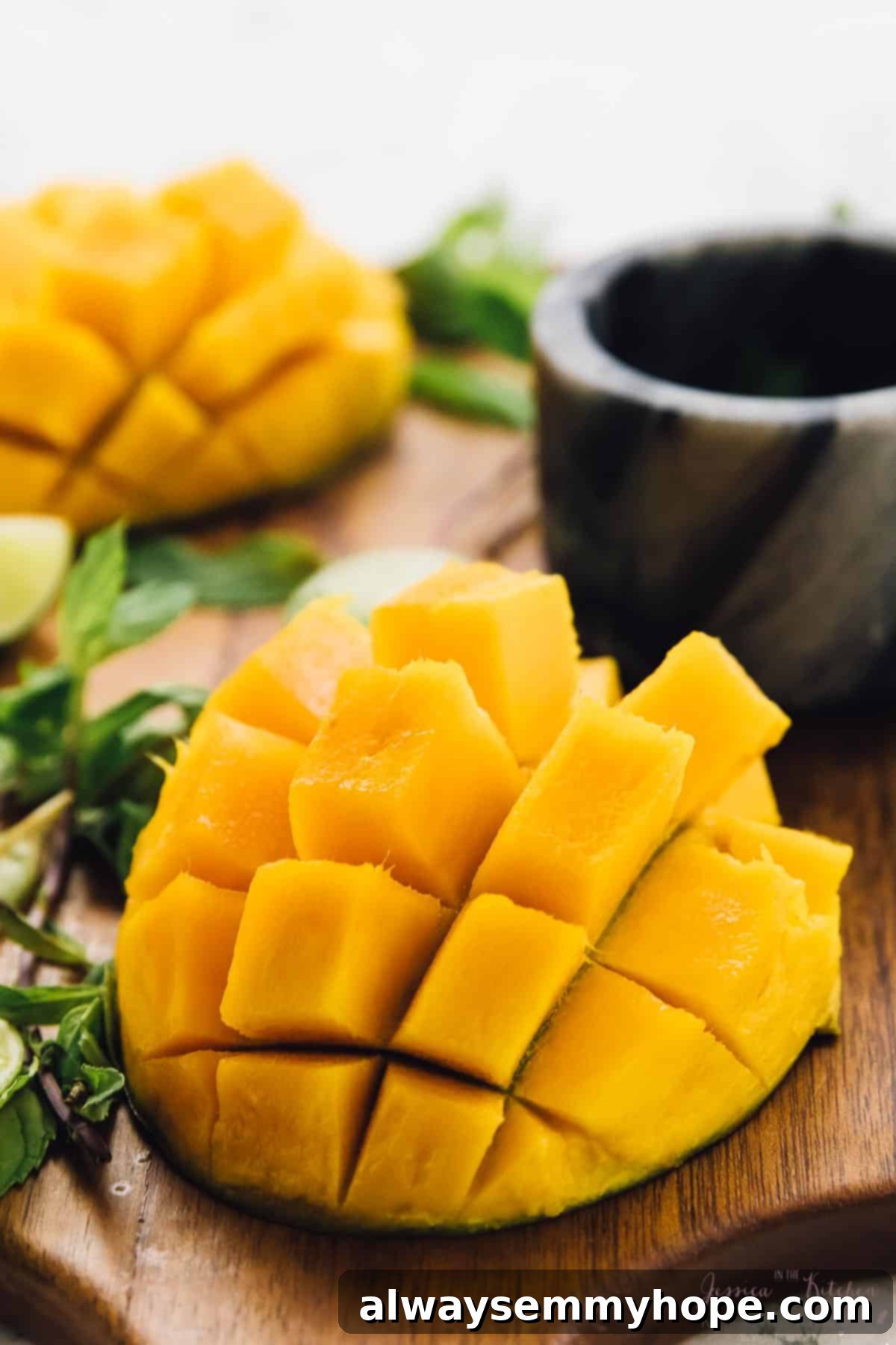 Freshly cubed mangoes on a wooden cutting board, ready for blending into a delicious mojito.