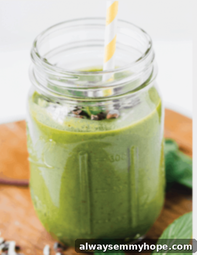Seven Day Smoothie Reset Win A Prize 8 A refreshing mint chocolate chip smoothie served in a clear mason jar with a bright yellow striped straw, elegantly garnished with fresh mint leaves and chocolate shavings, offering a cool and indulgent treat.
