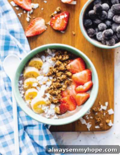 Seven Day Smoothie Reset Win A Prize 10 Overhead shot of a delightful banana smoothie bowl generously topped with fresh, sliced strawberries and delicate shredded coconut, presenting a perfect, healthy, and visually appealing treat.