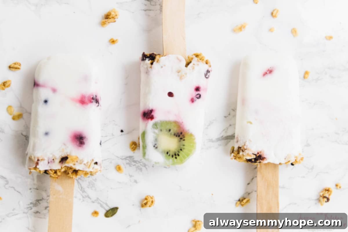 Three parfait popsicles on a white counter top. 