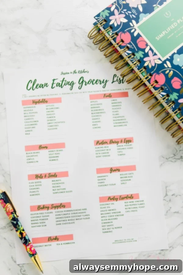 A printed clean eating grocery list on a table with a pen and notebook.