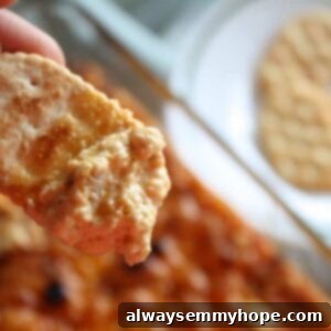 Irresistible Vegan Buffalo Chicken Dip 2 Photo of a cracker in a chicken dip.