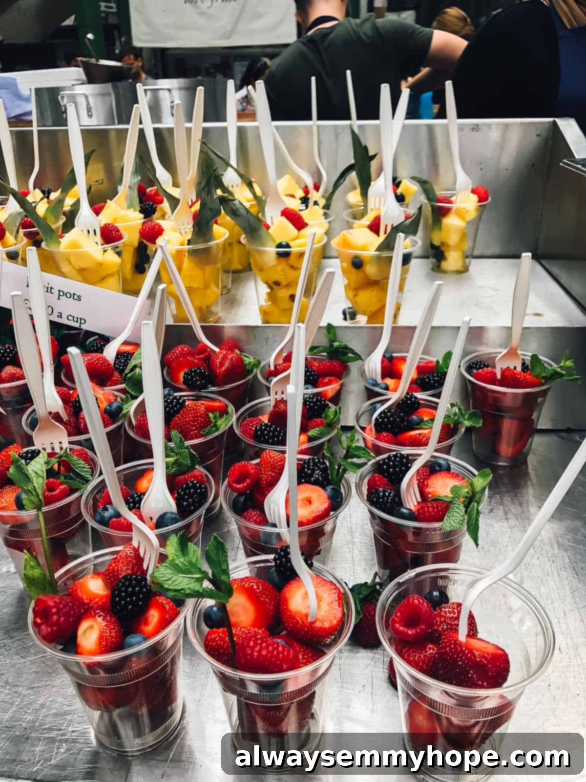 Your Essential Guide to London Food and Exploration 4 Plastic cups overflowing with fresh, vibrant berries at Borough Market.