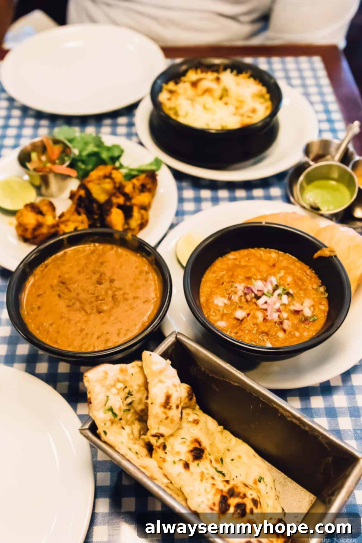 Your Essential Guide to London Food and Exploration 6 A beautifully arranged table spread with bowls of aromatic curry and warm naan bread at Dishoom.