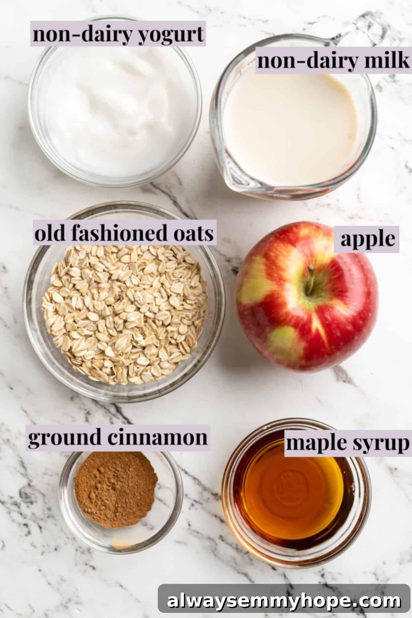 Apple pie overnight oats are packed with crisp apples, warm cinnamon, rich almond milk, and decadent maple syrup, and are an easy breakfast. Arrangement of ingredients for apple pie overnight oats, including rolled oats, sliced apples, cinnamon sticks, and a bottle of maple syrup, on a rustic surface.