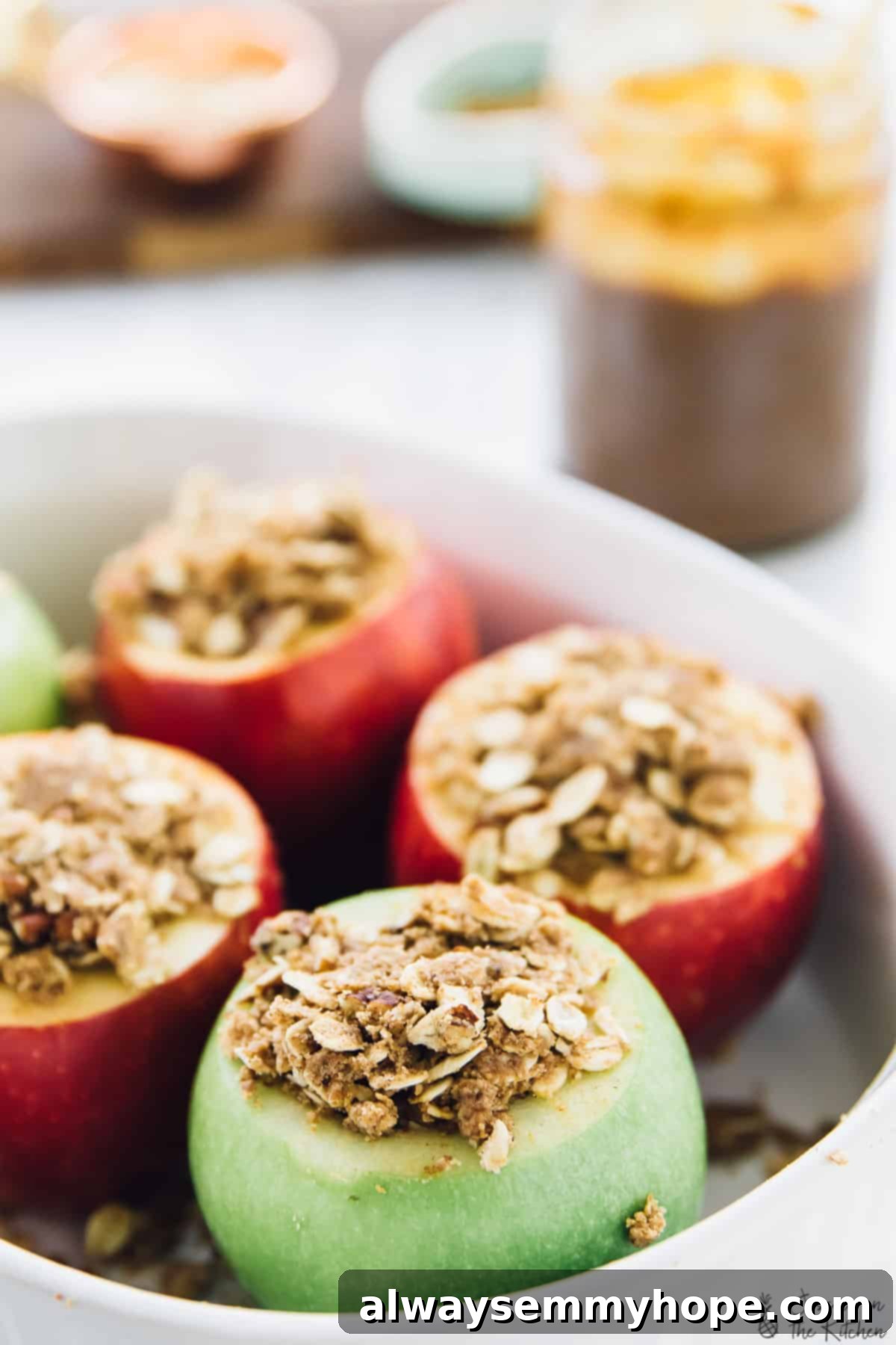 Cored apples filled with cinnamon oat crisp, awaiting baking for a delightful dessert. A close-up view of cored apples generously stuffed with a cinnamon oat crisp filling, nestled in a baking dish, perfectly prepped and ready for the oven.