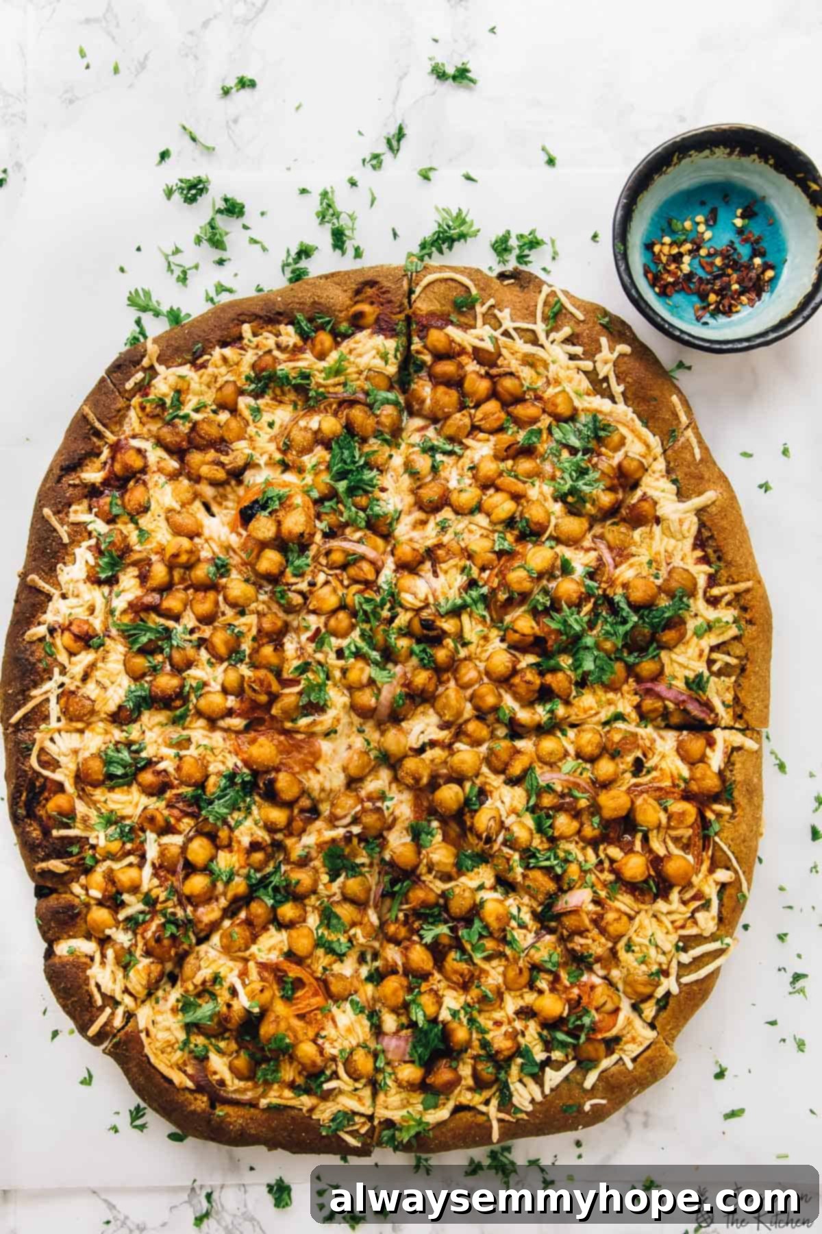 Spicy BBQ chickpea pizza: A delicious vegan alternative to BBQ chicken pizza, packed with flavor and ready in a flash. Overhead view of a freshly baked and garnished spicy BBQ chickpea pizza, with vibrant parsley contrasting against the rich colors of the toppings.