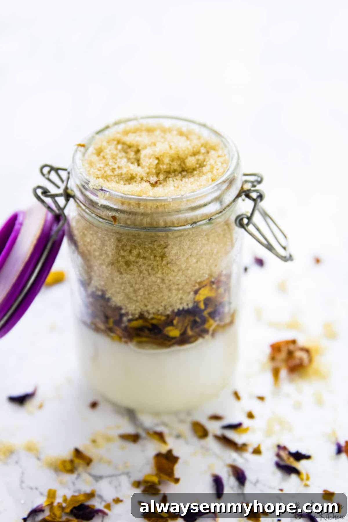 Side view of the homemade coconut rose sugar scrub, showcasing its texture and the visible rose petal pieces.