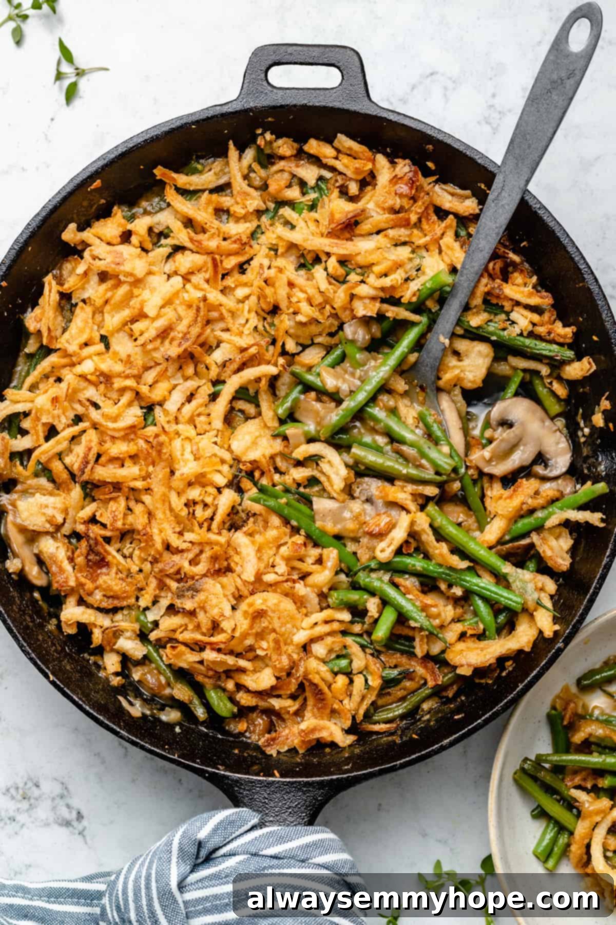 Green bean casserole in cast iron skillet with spoon