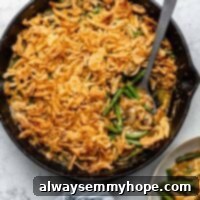 Overhead shot of vegan green bean casserole in cast iron skillet with spoon