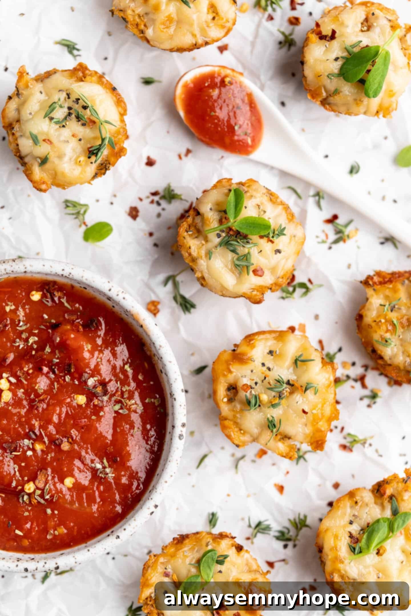 Overhead shot of vegan cauliflower pizza bites served with a bowl of marinara sauce and a spoon, ready for dipping.