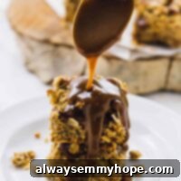 A spoon drizzling caramel sauce over vegan apple pie bars.