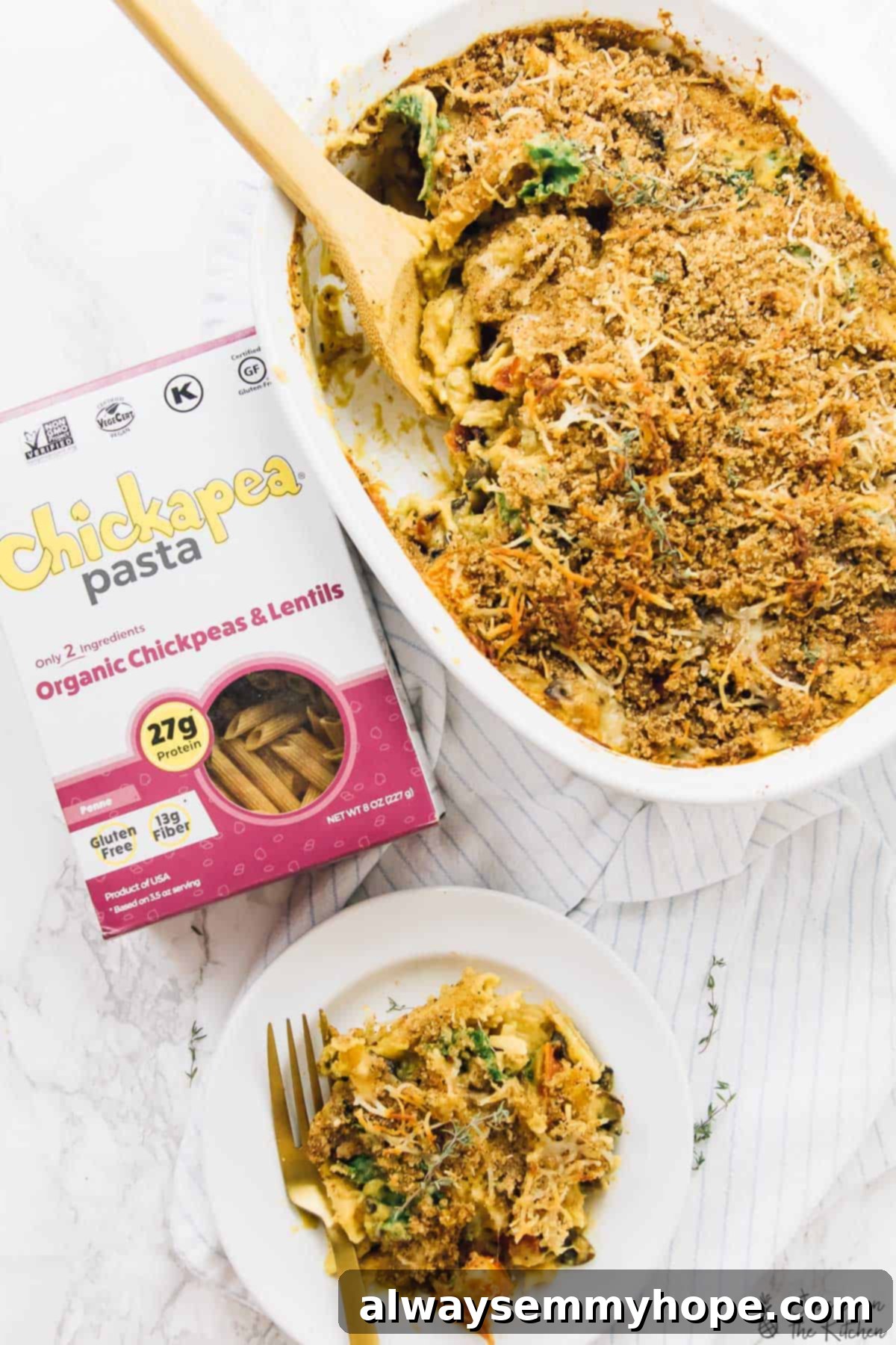 Butternut Squash Pasta Bake Enter to Win a Vitamix Blender 23 Top down view of a creamy butternut squash pasta bake on a plate, with a full baking dish in the background, garnished with fresh herbs.