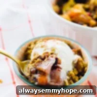 Bowl of apple cranberry crisp with a spoon scooping some out.