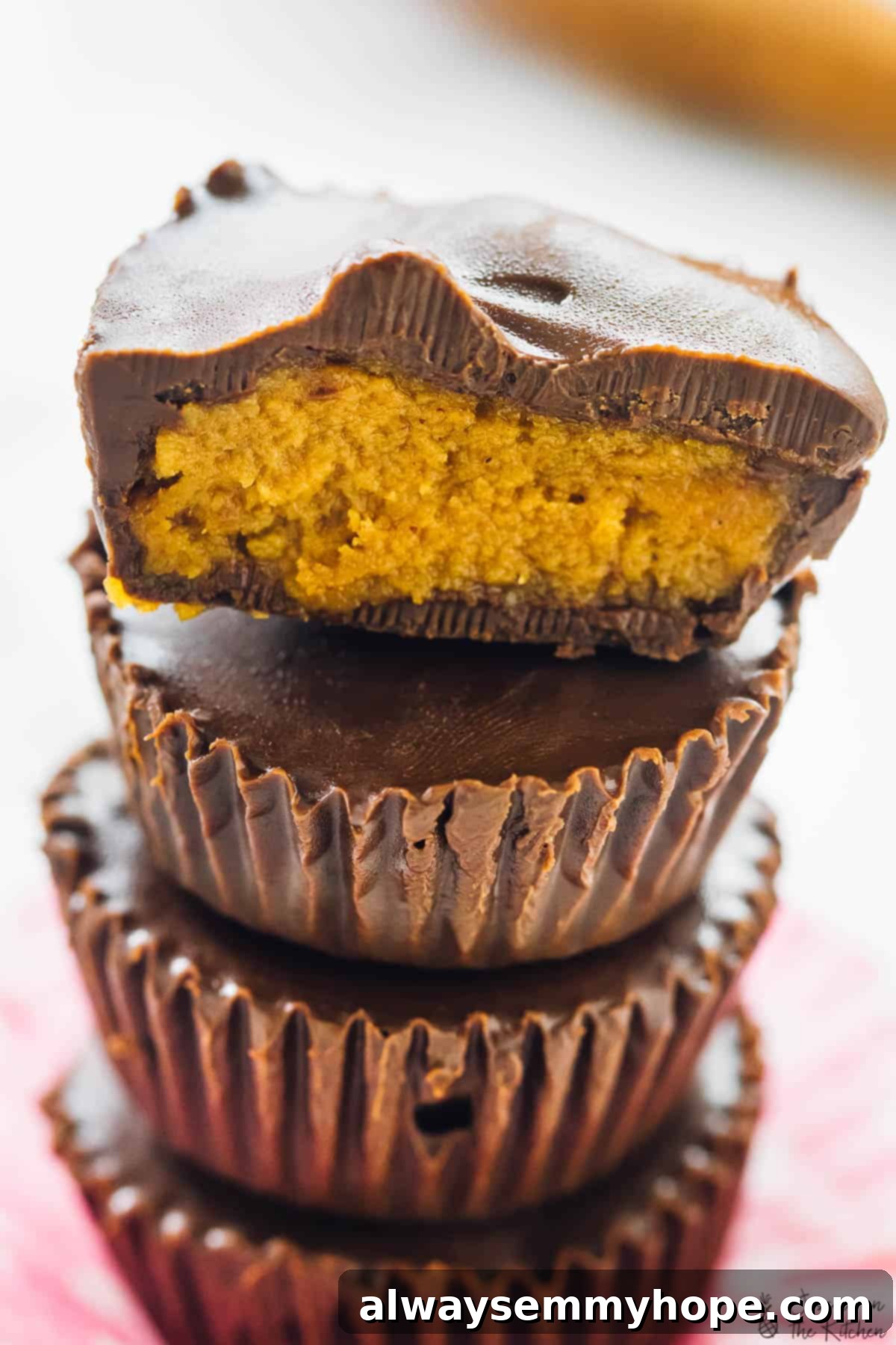 Close-up of a stack of five pumpkin chocolate cups, highlighting their texture.