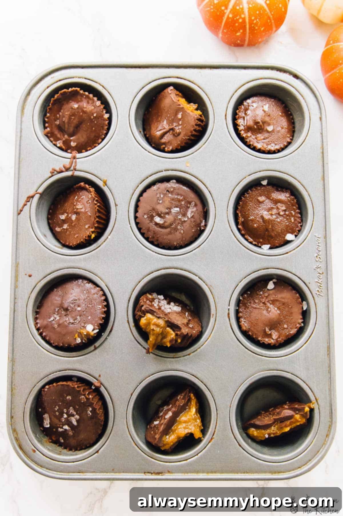 An overhead shot showcasing an array of freshly made salted caramel chocolate cups nestled in a mini muffin tray.
