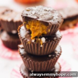 A pile of delightful salted caramel chocolate cups, showcasing their golden caramel peeking through and topped with sea salt.