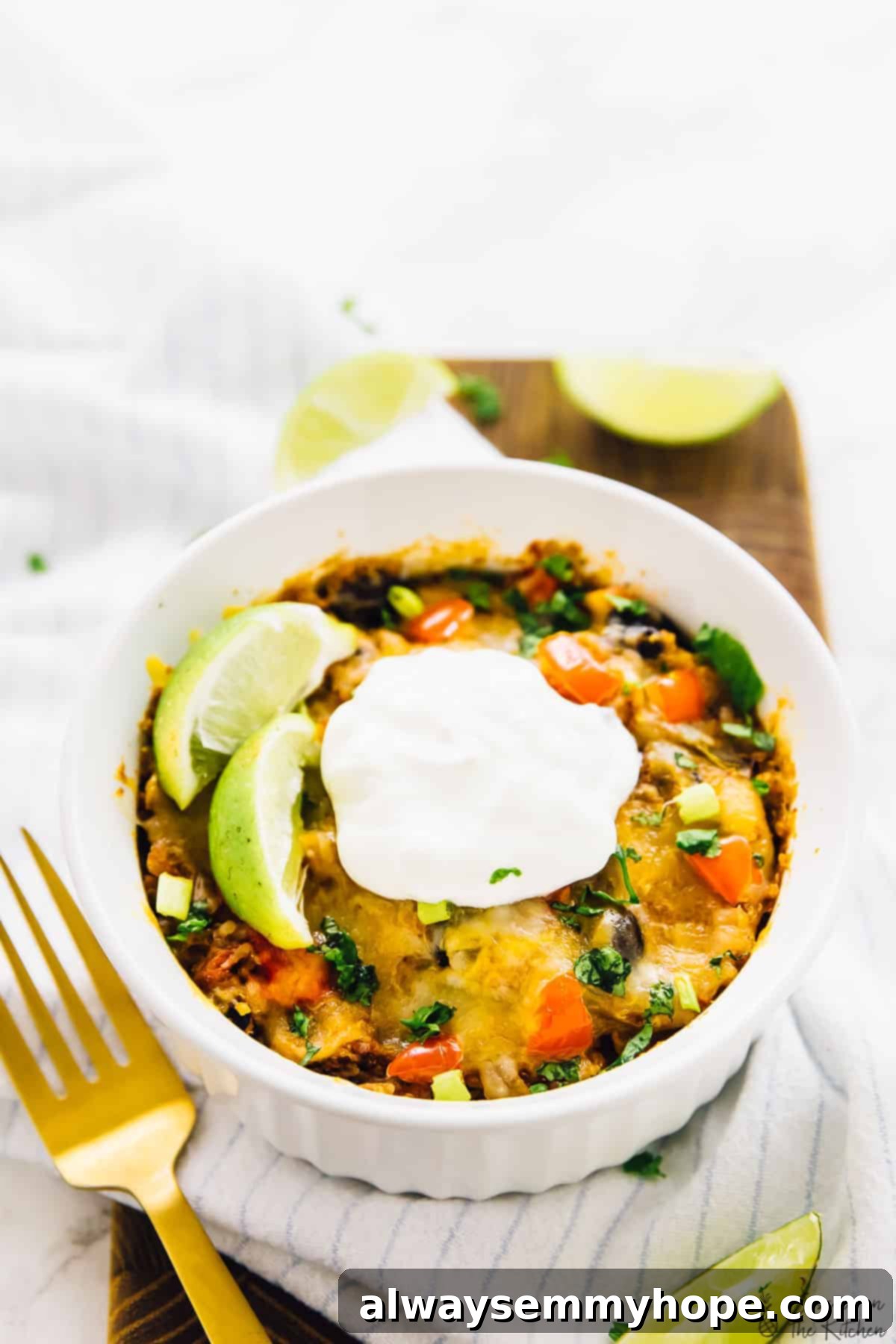 A single serving of quinoa enchilada casserole in a small white ramekin, garnished beautifully.