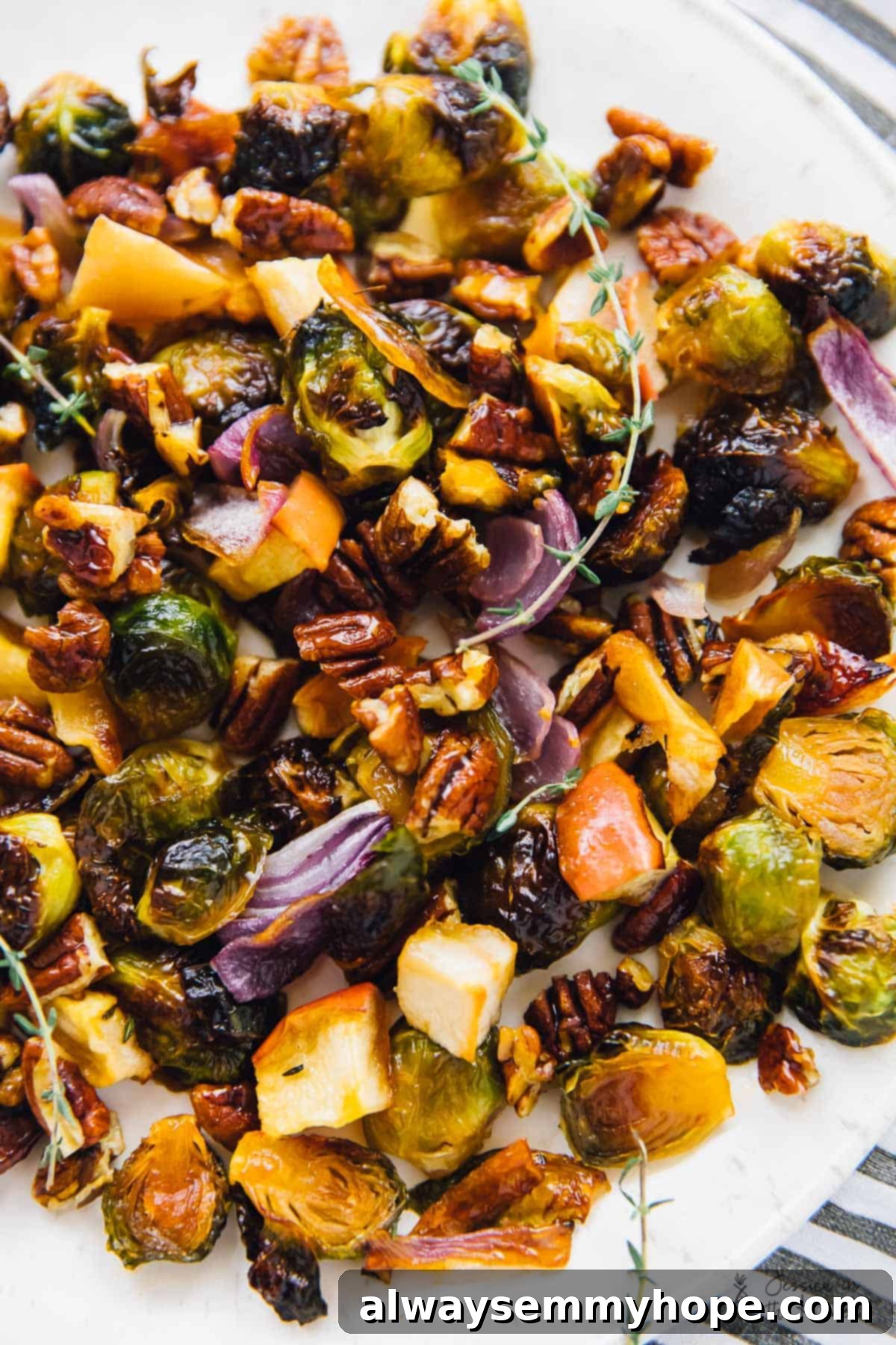 Maple roasted brussels sprouts with apples and pecans on a large plate. 