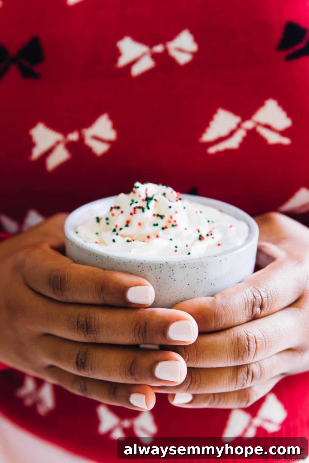 5 Ways to Find Holiday Calm, No Cooking Required 2 Hands gently holding a grey ceramic cup, with a soft, festive background.