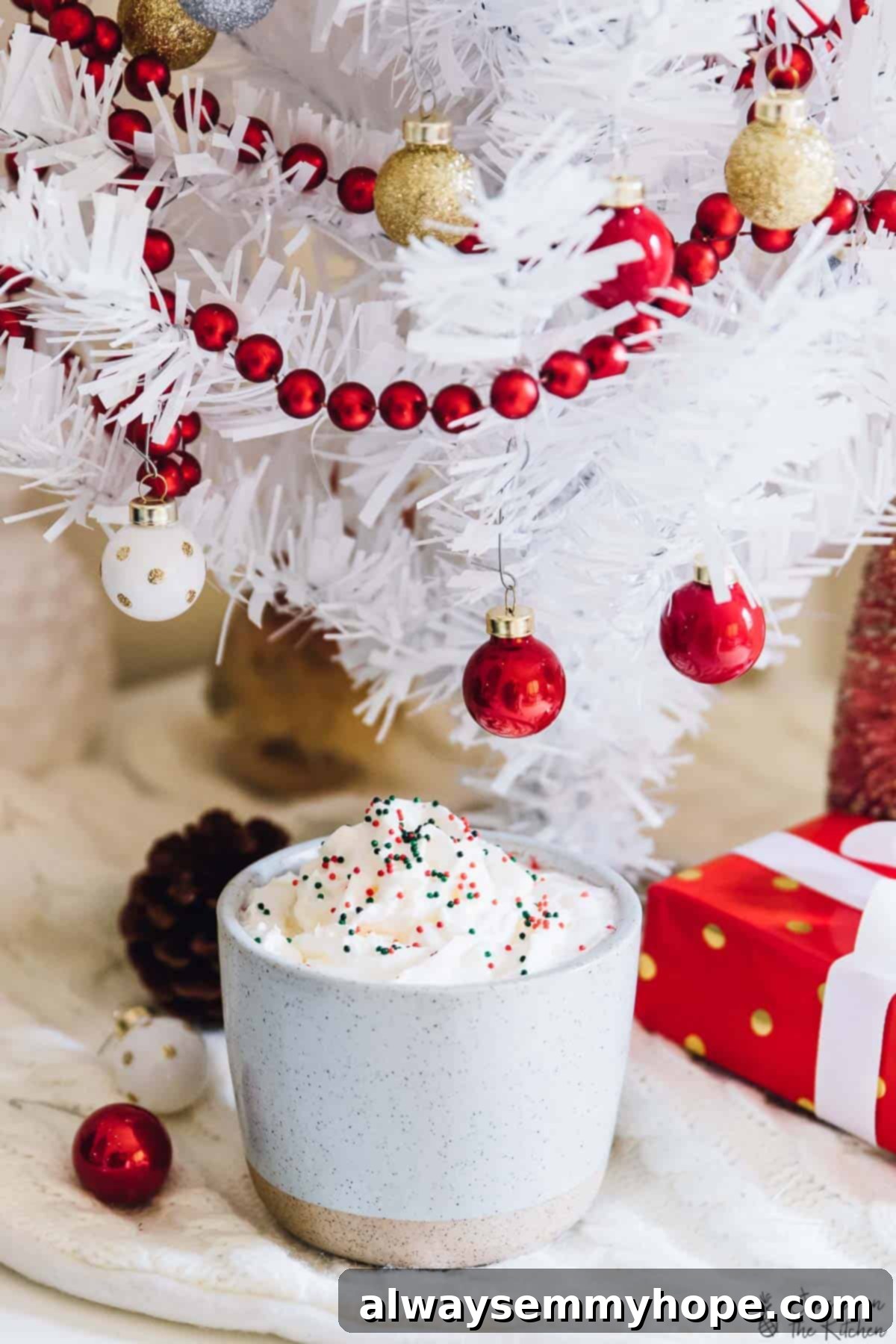 5 Ways to Find Holiday Calm, No Cooking Required 3 A warm cup of hot chocolate placed on a cozy rug, with a soft-focus white Christmas tree in the background.