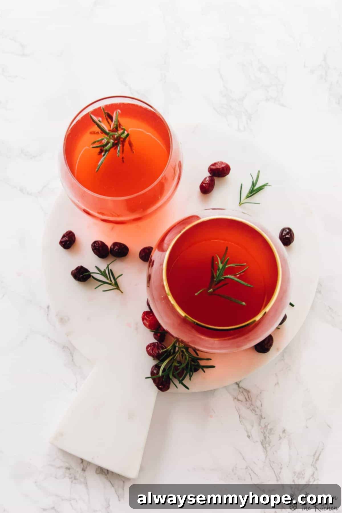 Top down shot of cranberry gin cocktails on a white table. 