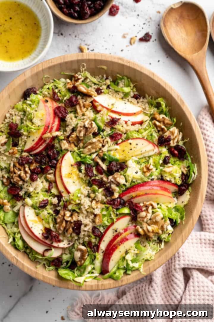 Overhead view of a vibrant shaved Brussels sprouts salad in a serving bowl, showcasing all added ingredients.
