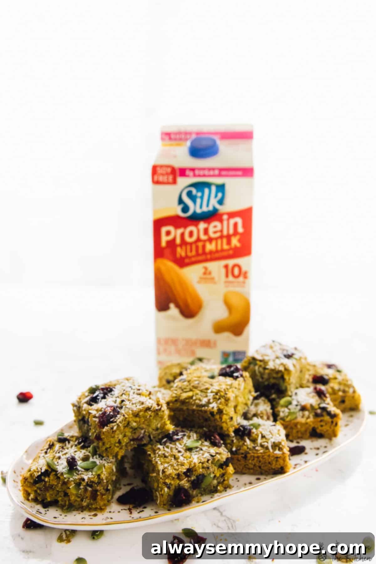 My Progress Morning Routine Featuring Quinoa Breakfast Bars 12 A beautifully arranged plate of quinoa breakfast bars with a carton of Silk Protein Nutmilk in the background, highlighting the nutritious components of a balanced breakfast.