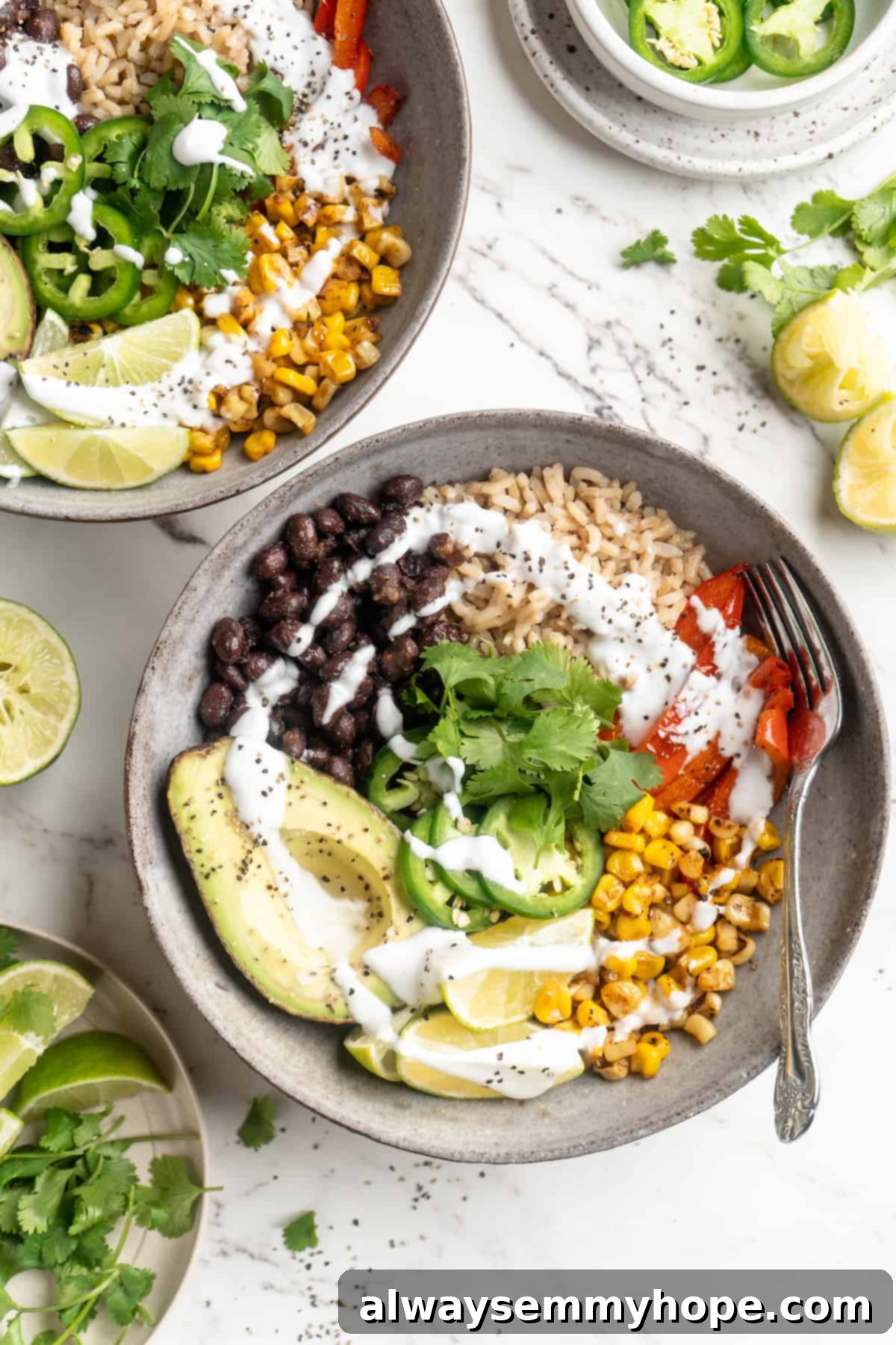Overhead view of two vibrant vegan burrito bowls beautifully presented on a wooden table, ready to be enjoyed.