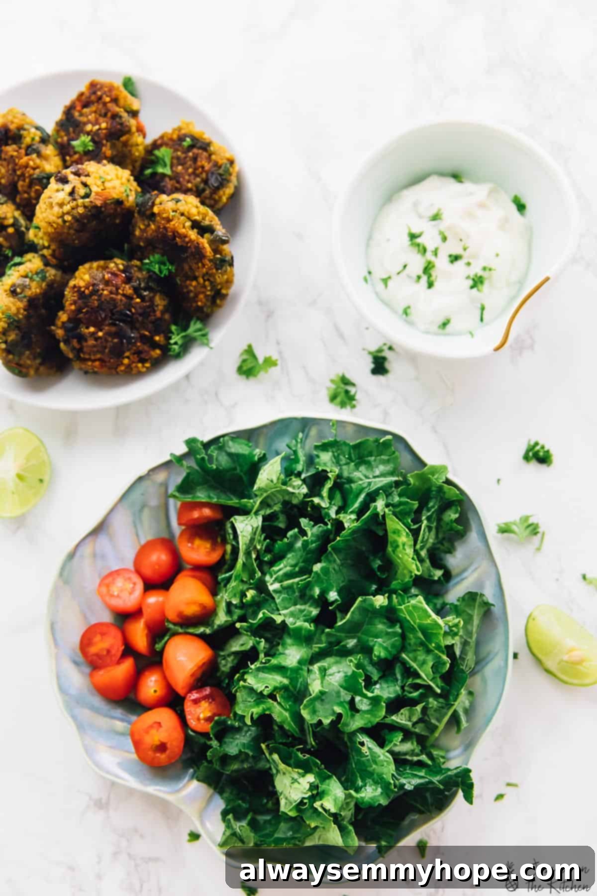 Overhead view of bowl of quinoa patties, bowl of tahini yogurt sauce, and plate of greens and tomatoes An overhead shot showcasing a complete meal: a bowl of freshly cooked, crispy quinoa patties, a separate bowl of creamy tahini yogurt sauce, and a plate featuring a vibrant bed of fresh greens and cherry tomatoes.