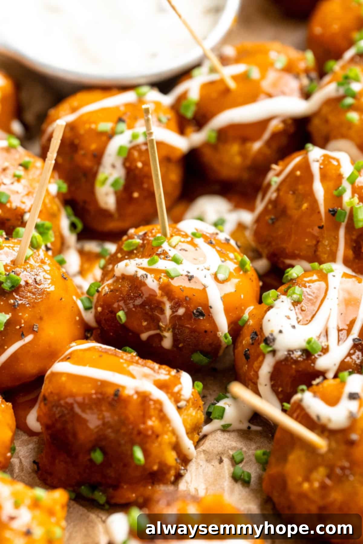 Buffalo cauliflower meatballs on toothpicks with ranch drizzle.