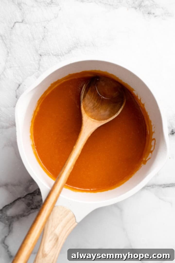 Vegan Buffalo sauce in pan with wooden spoon.