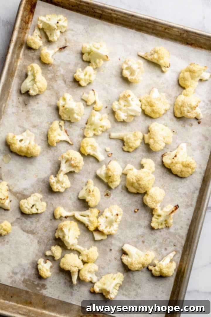 Roasted cauliflower on parchment-lined sheet pan.