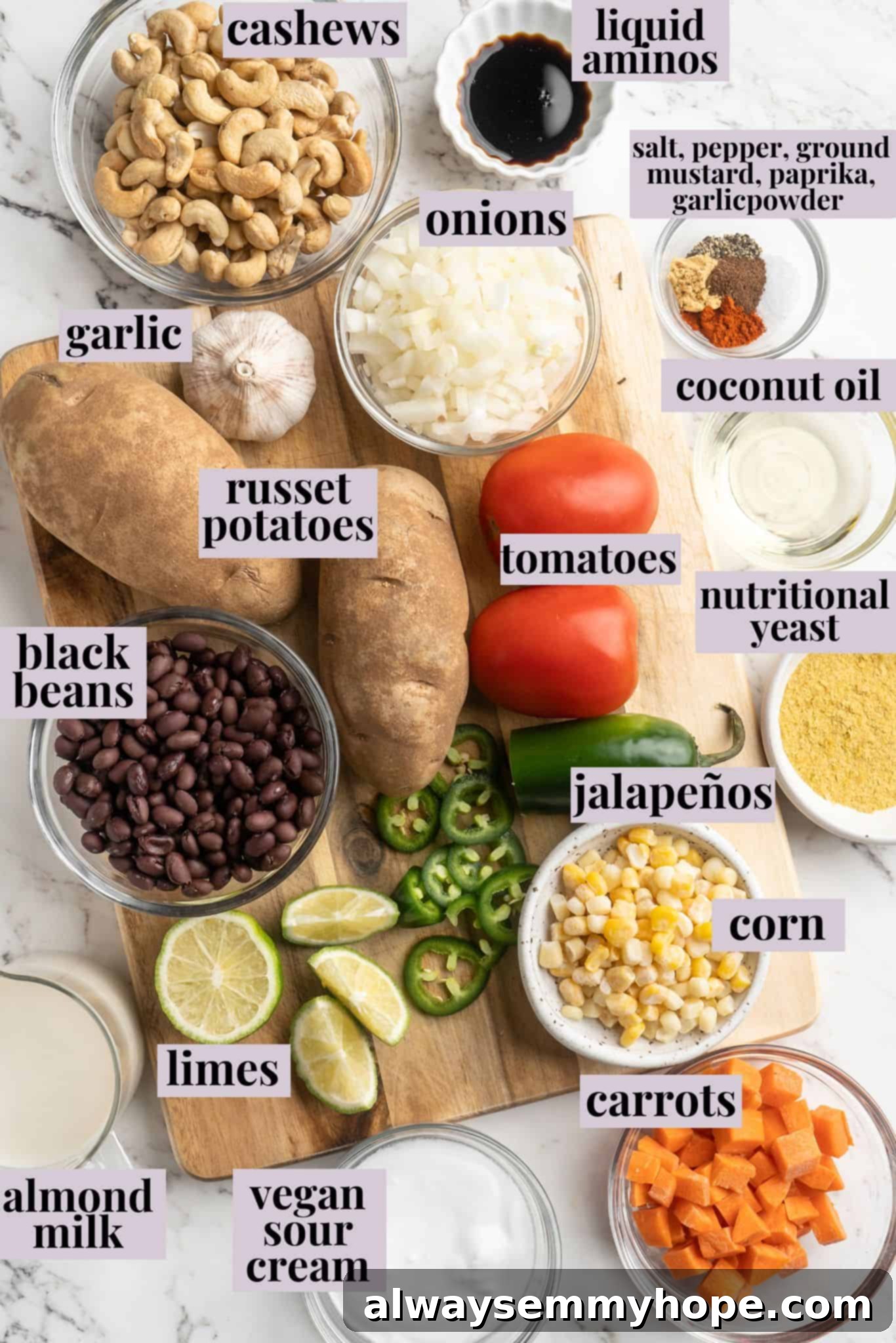 Get the party started with loaded nacho fries! They're topped with all your favourite nacho toppings to create an irresistible appetizer. Overhead view of all ingredients for vegan nacho fries laid out on a white surface, including potatoes, cashews, vegetables, and spices.