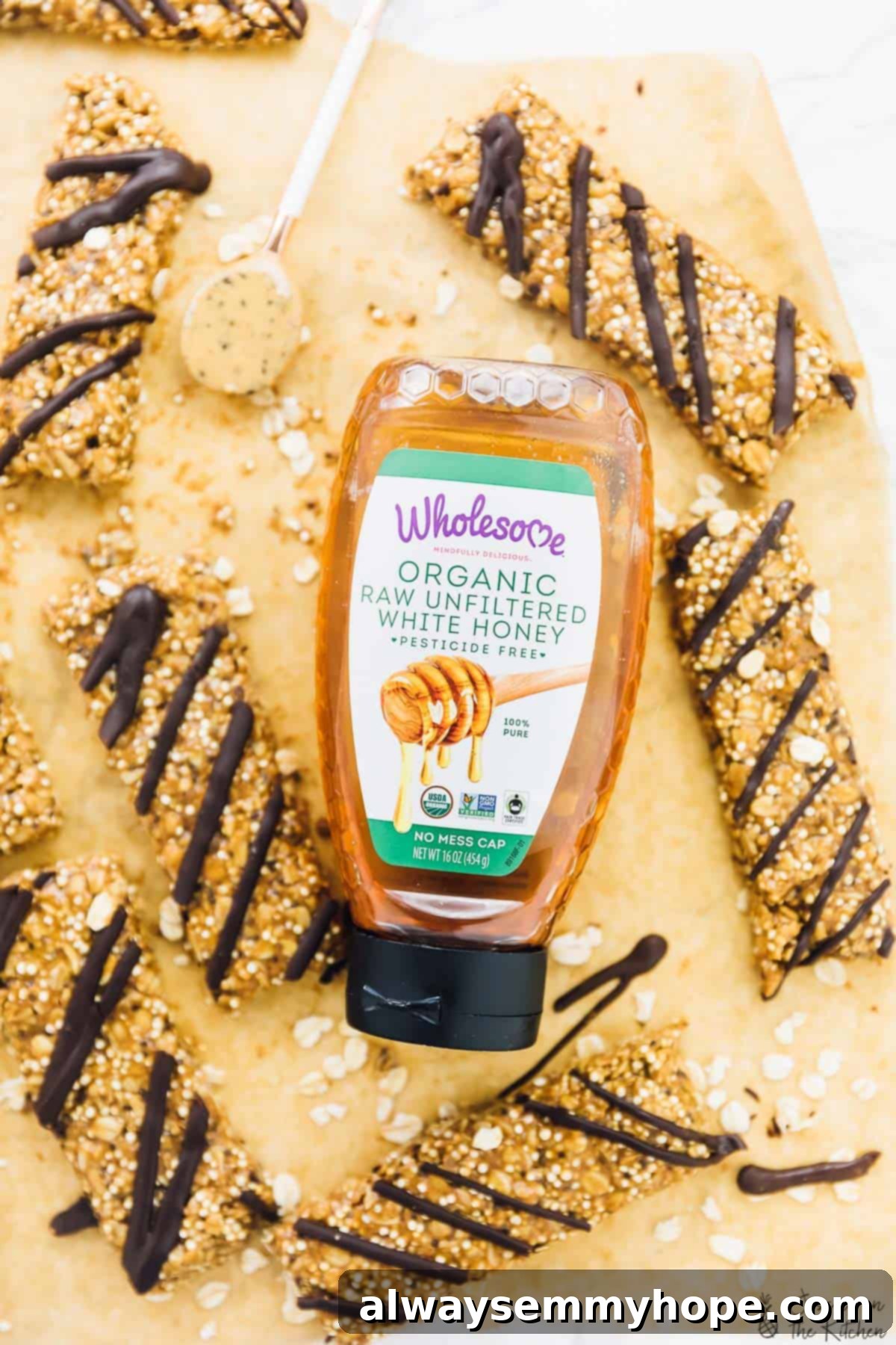 No-Bake Salted Honey Dark Chocolate Quinoa Coconut Delights 3 Top-down shot of freshly made salted honey, dark chocolate, coconut, and quinoa no-bake granola bars arranged on a rustic wooden board, with a small bottle of Wholesome Honey in the background.