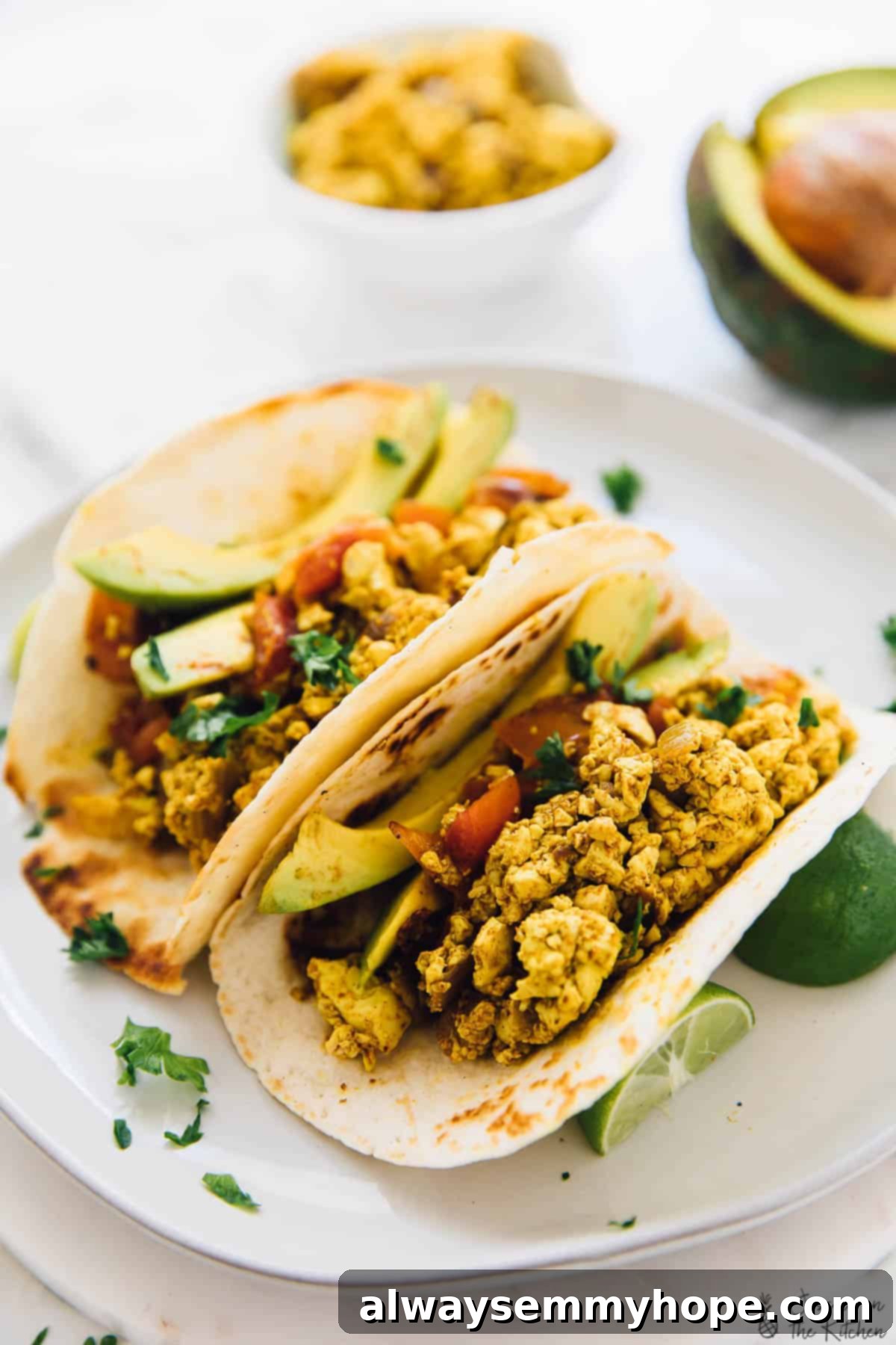 Two breakfast tacos generously filled with Southwestern tofu scramble, ready for serving, highlighting the taco presentation.