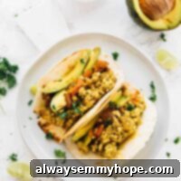 Overhead shot of Southwestern tofu scramble in soft tortillas, garnished with cilantro.