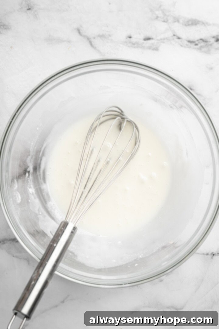 These easy carrot cake muffins bake up in just 30 minutes and are absolutely fantastic. Moist, delectable, vegan and gluten-free! Glaze in bowl with whisk