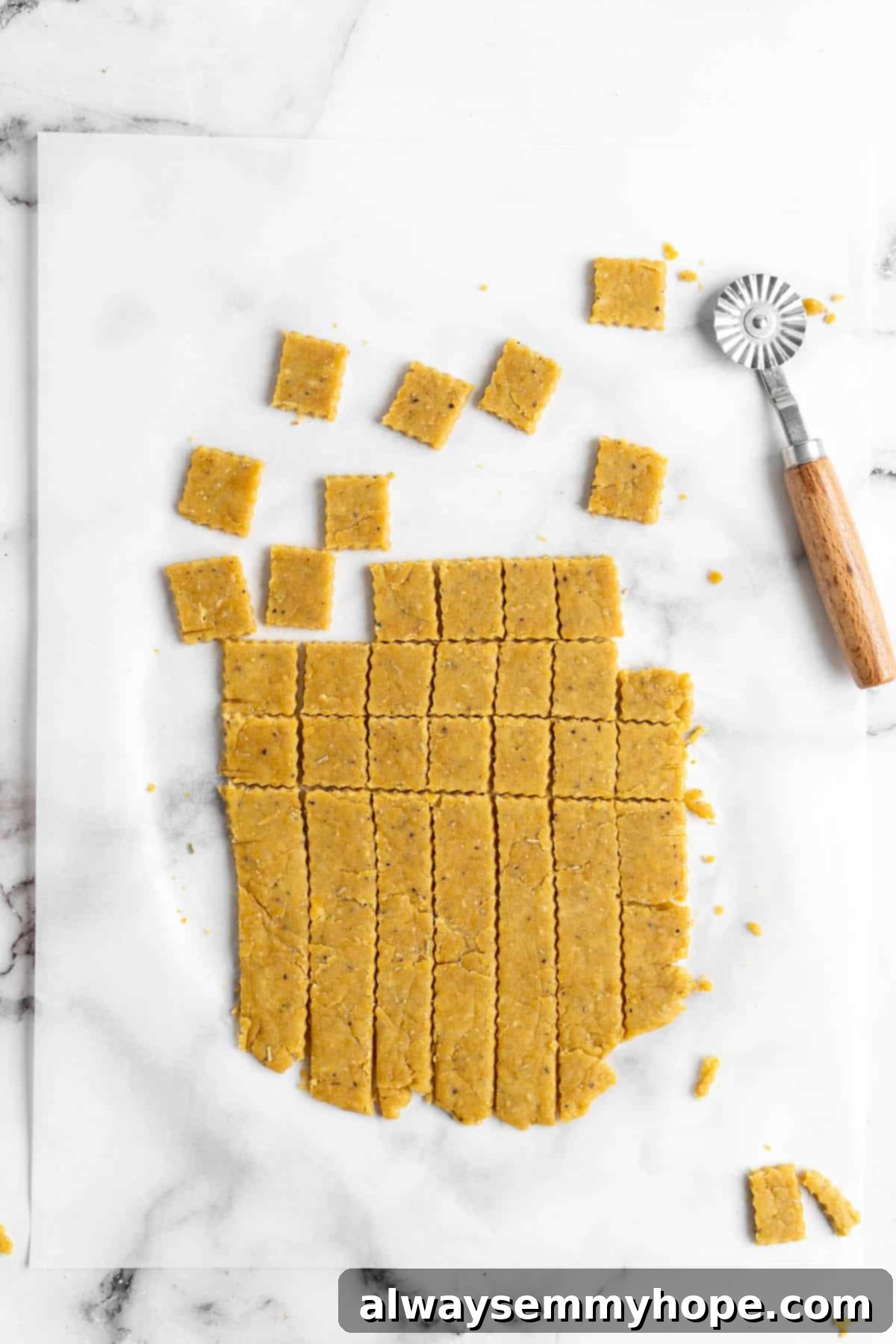 These vegan Cheez-Its are crispy, crunchy, snackable, and super cheesy! Make your own homemade vegan cheese crackers in just 30 minutes. Overhead view showing vegan cheese crackers being cut