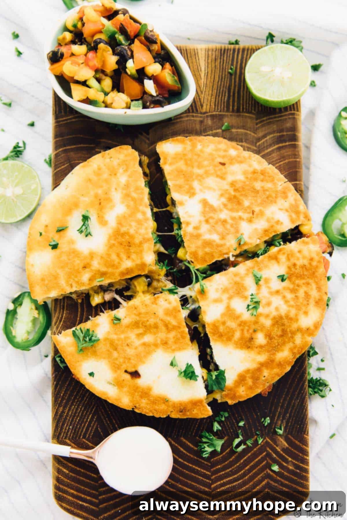 These easy black bean and corn quesadillas are done in just 15 minutes, making them perfect for a quick weeknight dinner! Overhead view of a delicious black bean and corn quesadilla cut into wedges