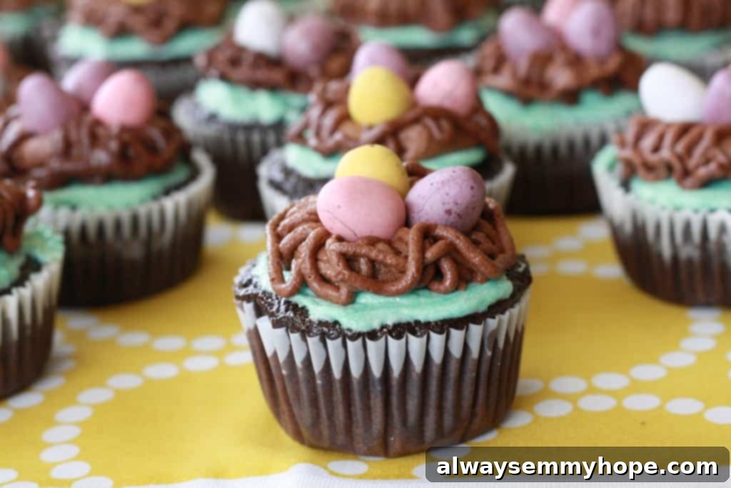 Cute Bird's Nest Easter Cupcakes. Easy to make and fun to eat, with chocolate Easter eggs to set them off. Two perfectly decorated bird's nest Easter cupcakes on a vibrant yellow tablecloth, showcasing their intricate chocolate nests and colorful eggs.