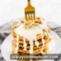 Vegan Carrot Cake Pancakes with Maple Cream Cheese 9 A gold fork in a stack of pancakes.