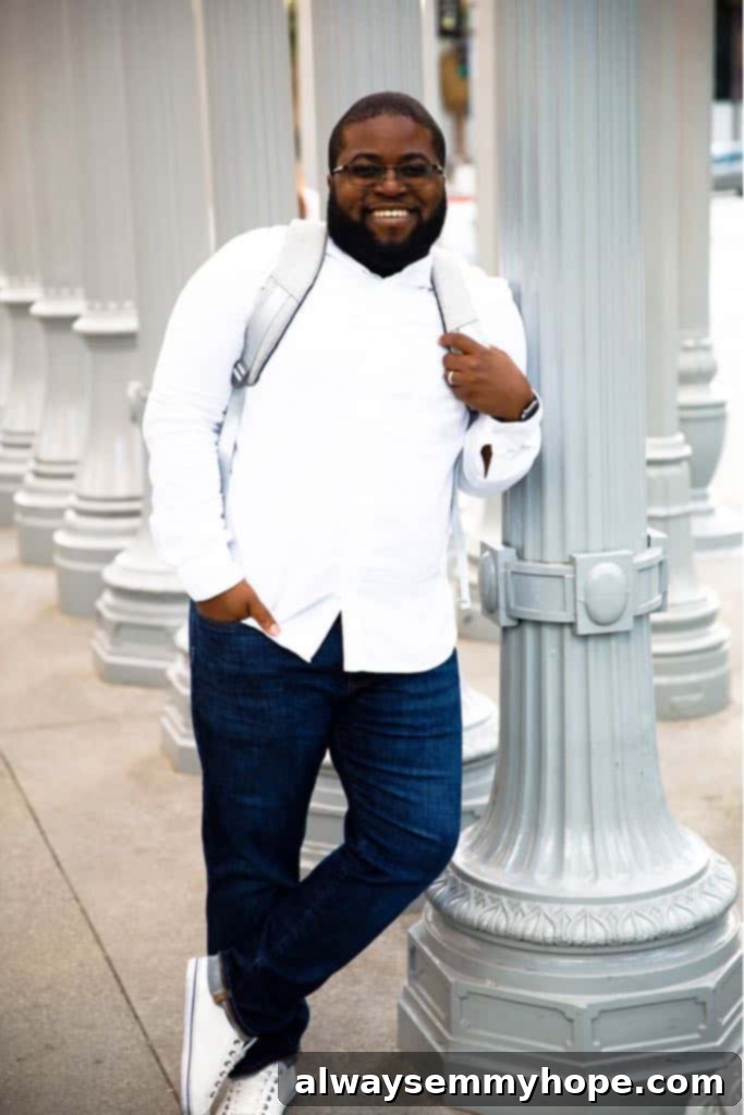 Gavin leaning against a lamp post and smiling. 