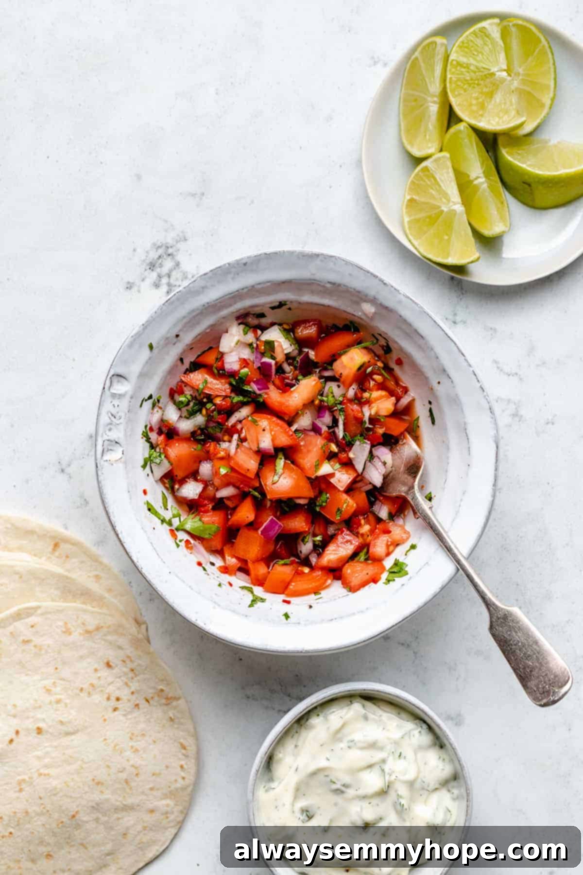 Golden Beer Battered Vegan Fish Tacos 4 Overhead shot of a bowl of fresh pico de gallo with a fork, showing the vibrant colors of diced tomatoes, onions, and herbs.