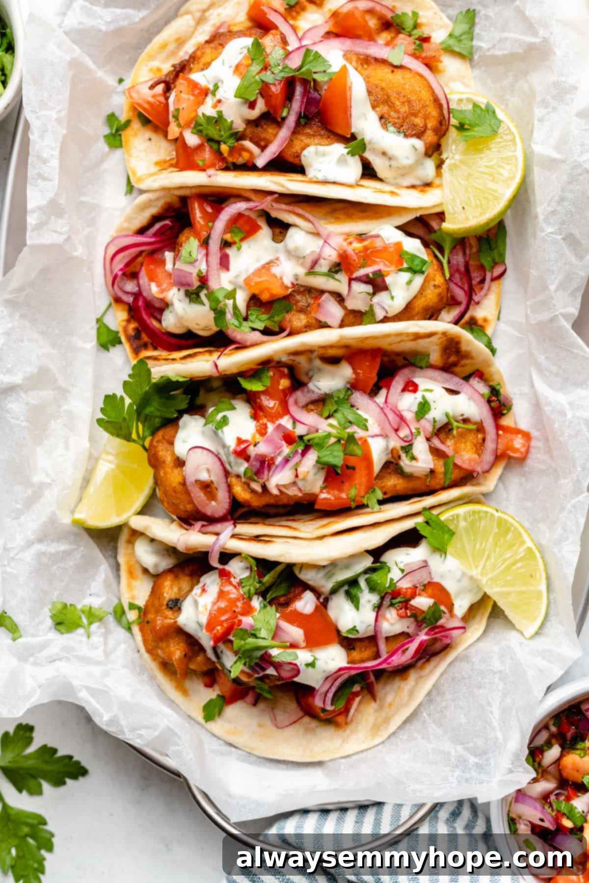 Golden Beer Battered Vegan Fish Tacos 7 Overhead close-up view of two beautifully arranged vegan fish tacos on a platter, highlighting the fresh toppings and crispy 'fish'.