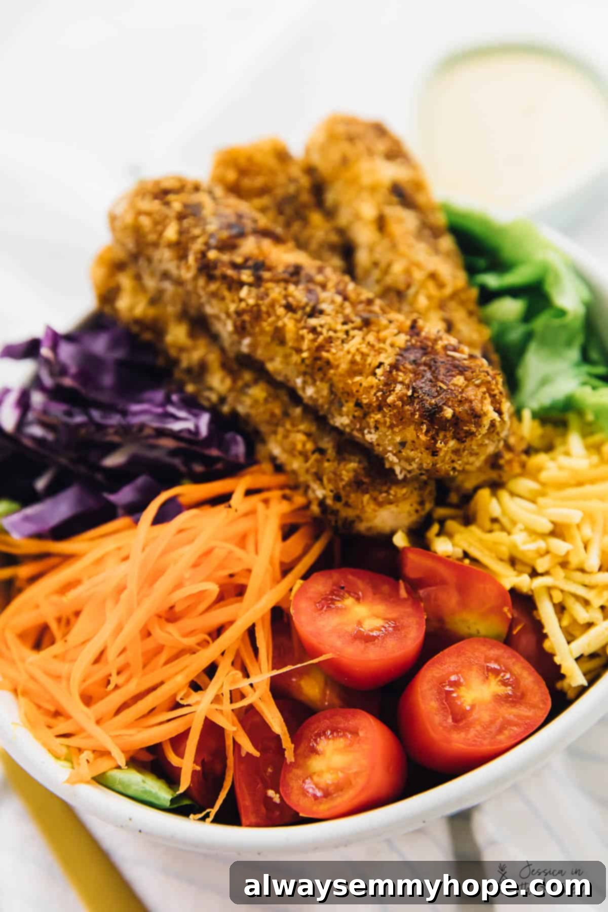Close-up of a vegan crispy Cajun fried tofu salad served in a elegant white bowl.