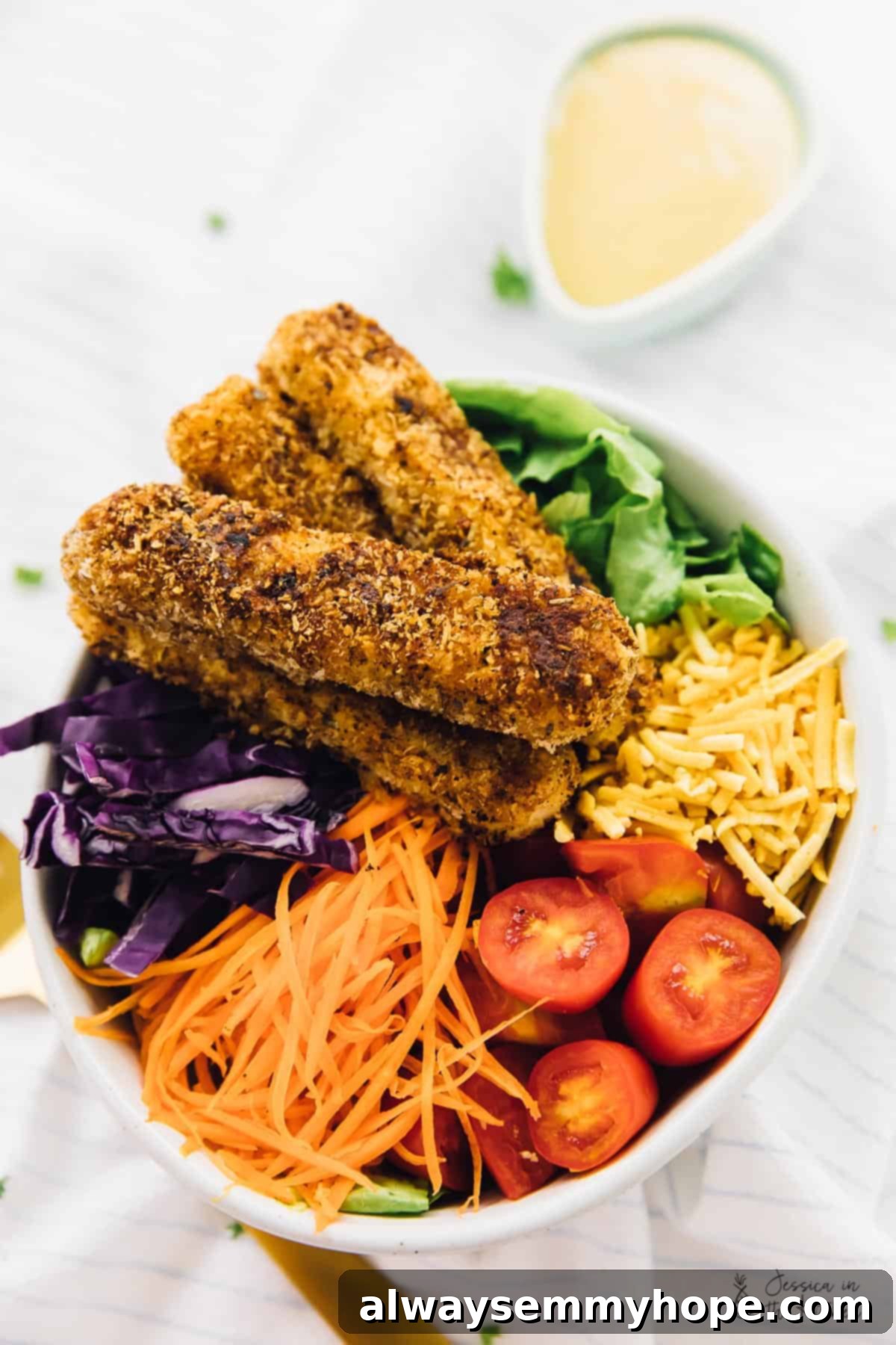 Top-down view of a vibrant vegan crispy Cajun fried tofu salad in a bowl, perfectly arranged.