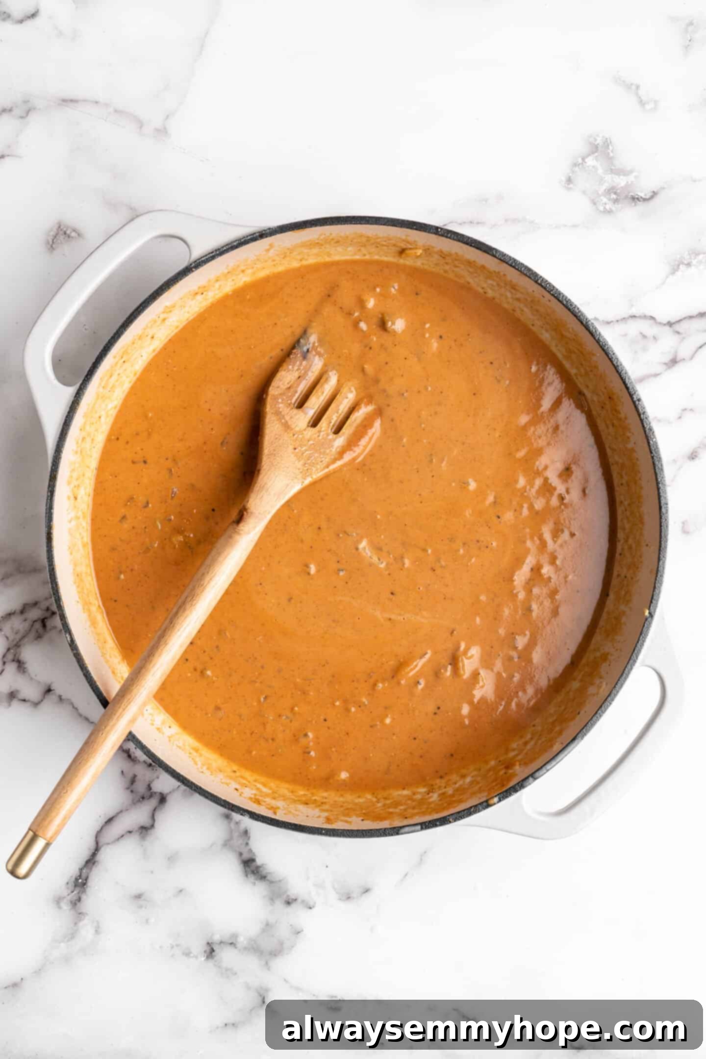 Overhead view of the creamy vegan butter chicken sauce simmering in a Dutch oven, rich and vibrant before adding tofu