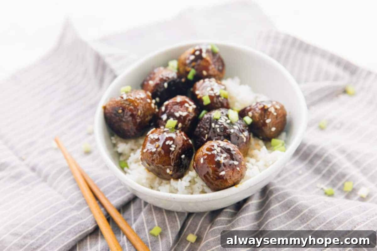 Vegan teriyaki meatballs are easy to make, slathered with flavor-packed homemade teriyaki sauce. Great for dinner, appetizers, or meal prep! A bowl of teriyaki meatballs served over rice with chopsticks on the side.